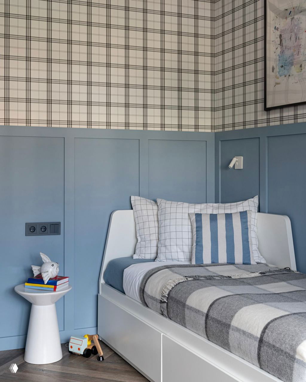 Детская или спальня в пастельных тонах: голубая панельная отделка стен, односпальная кровать и сдержанный текстиль с клетчатым узором.
