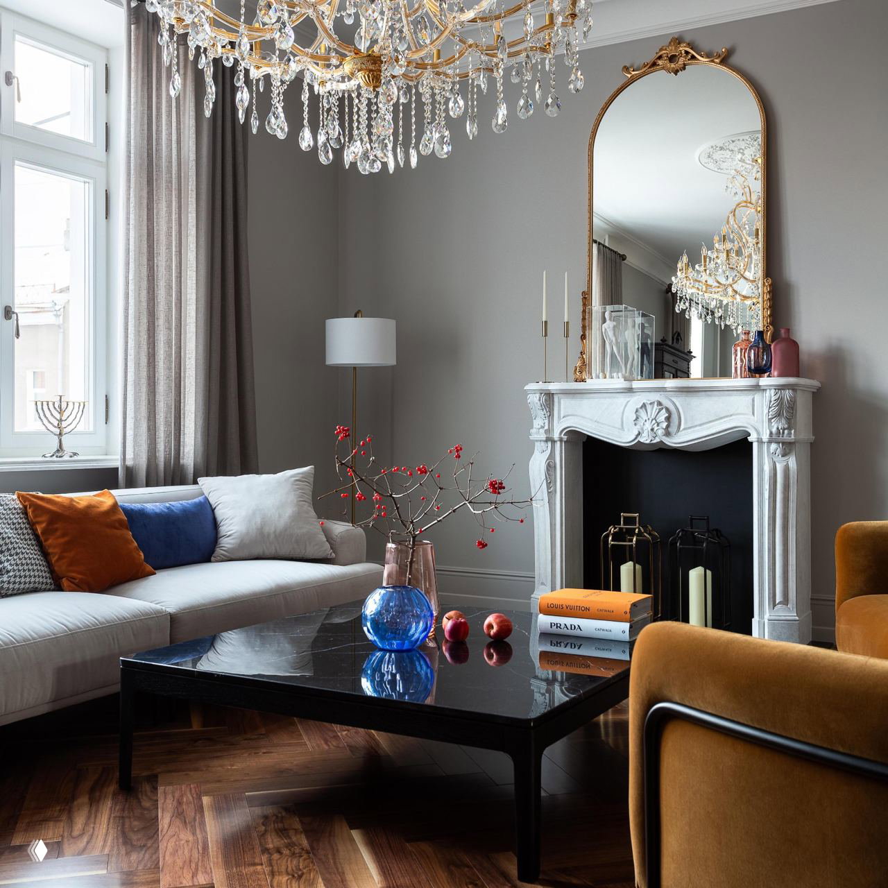 Гостиная с бежевой мебелью, зеркалом в золочёной раме и хрустальной люстрой с подвесками — мягкая, элегантная палитра и классические акценты.