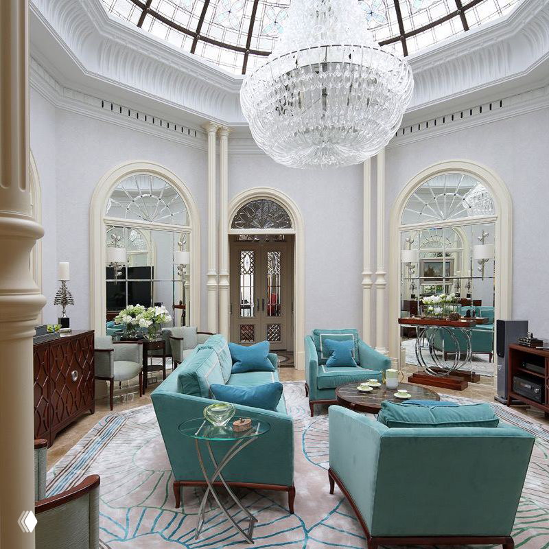 Круглая светлая гостиная с большим купольным потолочным окном и прозрачной стеклянной люстрой — светлая классика в просторном помещении с арками.