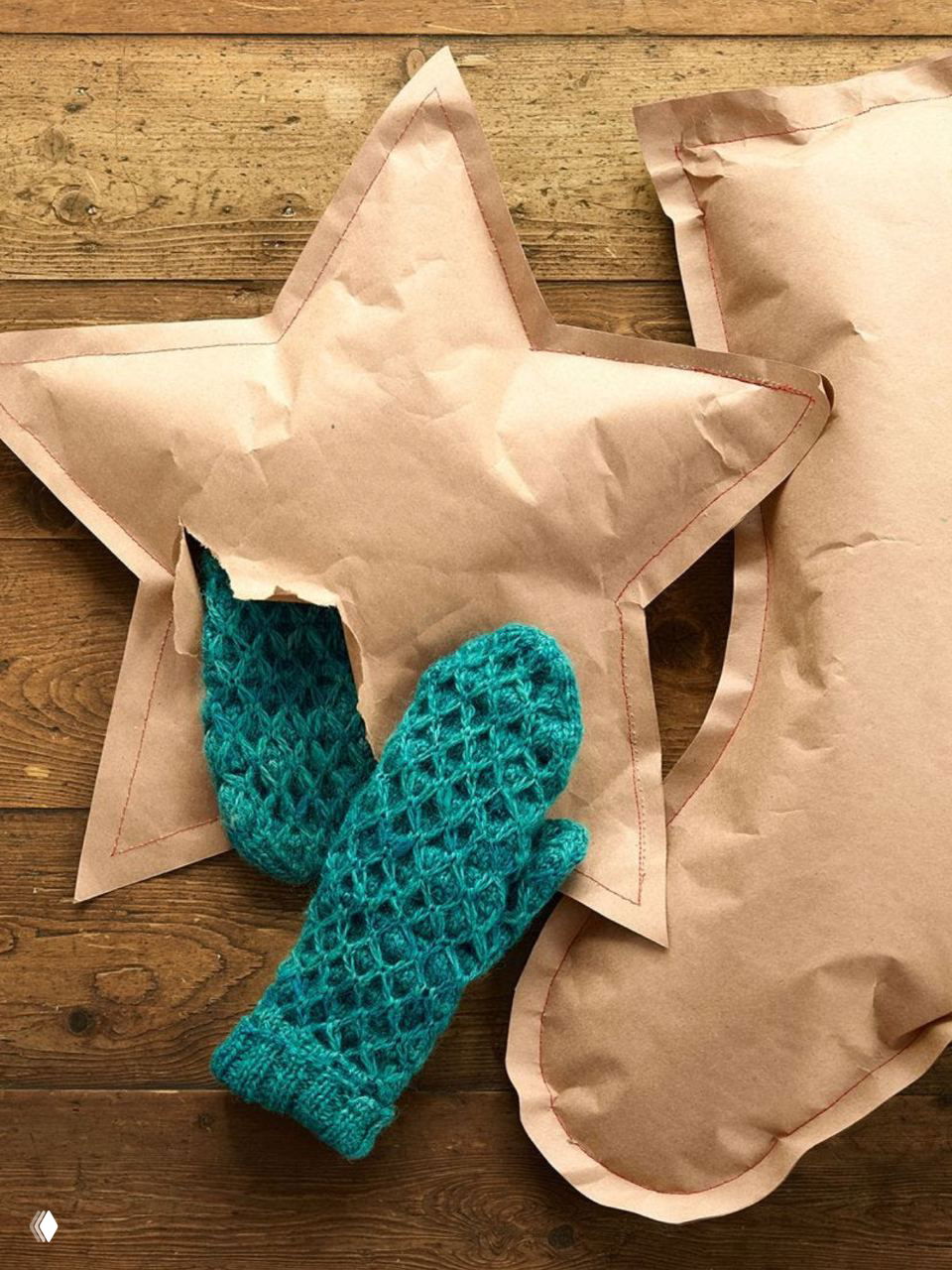 Тёплые вязаные варежки и мягкие подушки в форме звезды в коричневой бумажной обшивке — идеи текстильного и подарочного декора.