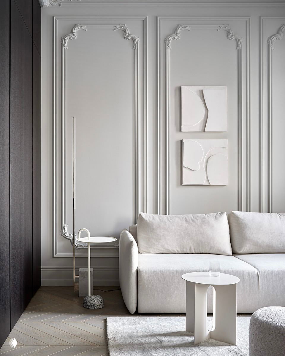 Светлая гостиная с молдингами, белым диваном и минималистичным кофейным столиком — нейтральная палитра и чистые архитектурные акценты.