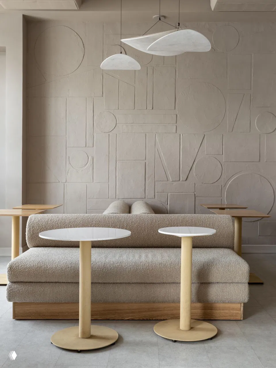 Центральная композиция: круглый бетонный стол с вазой, вокруг — зелёные стулья; интерьер максимально ориентирован на натуральные материалы.