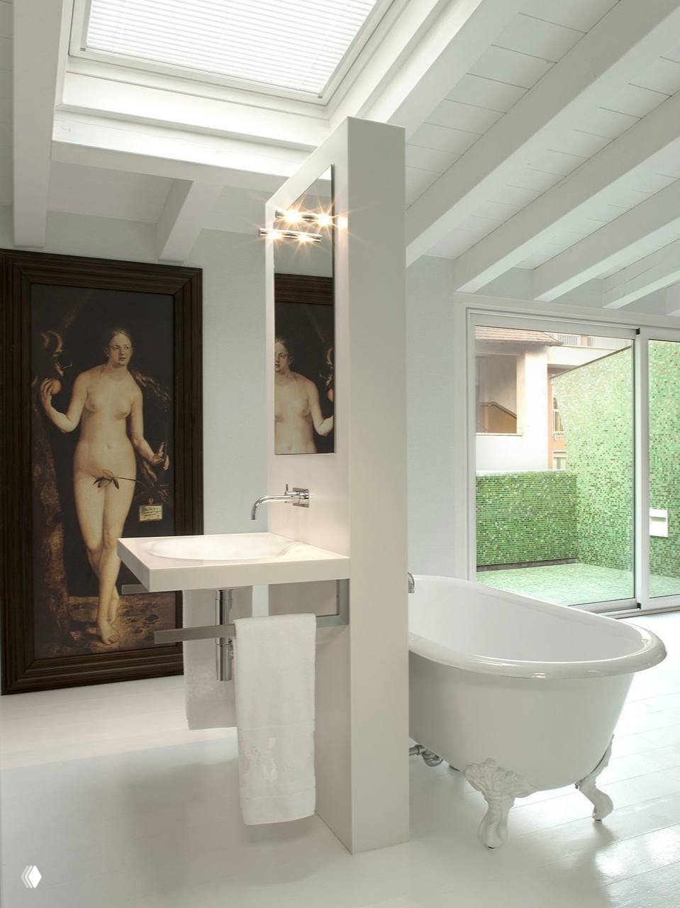 Светлая ванная с классической отдельностоящей ванной, раковиной и большим живописным полотном у стены в интерьере миланского дома.