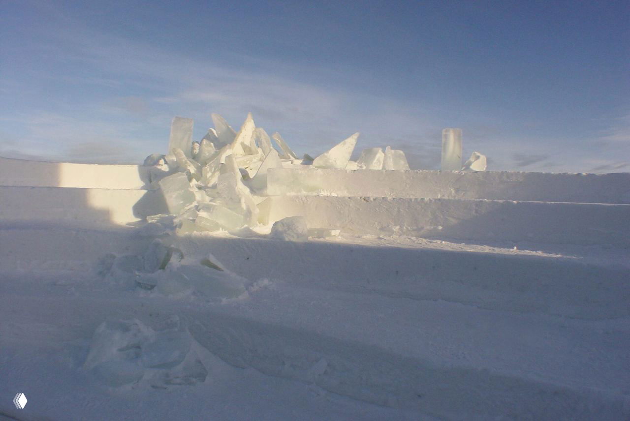 Фрагмент снежной инсталляции с обломанными ледяными блоками и ступенями: текстуры льда и снега в естественном холодном освещении.