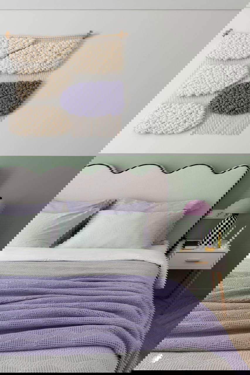 Спальня: изголовье кровати с волнистым профилем, зеленая покраска по низу стены и текстильные панно в пастельных тонах над кроватью.