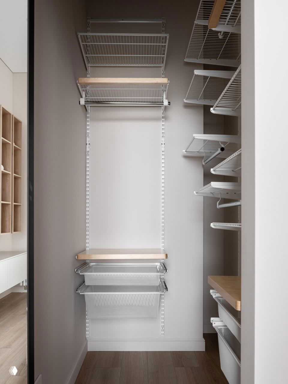 Узкая гардеробная с открытыми металлическими полками и выдвижными корзинами: функциональное решение хранения в небольшой квартире с приглушенной отделкой.