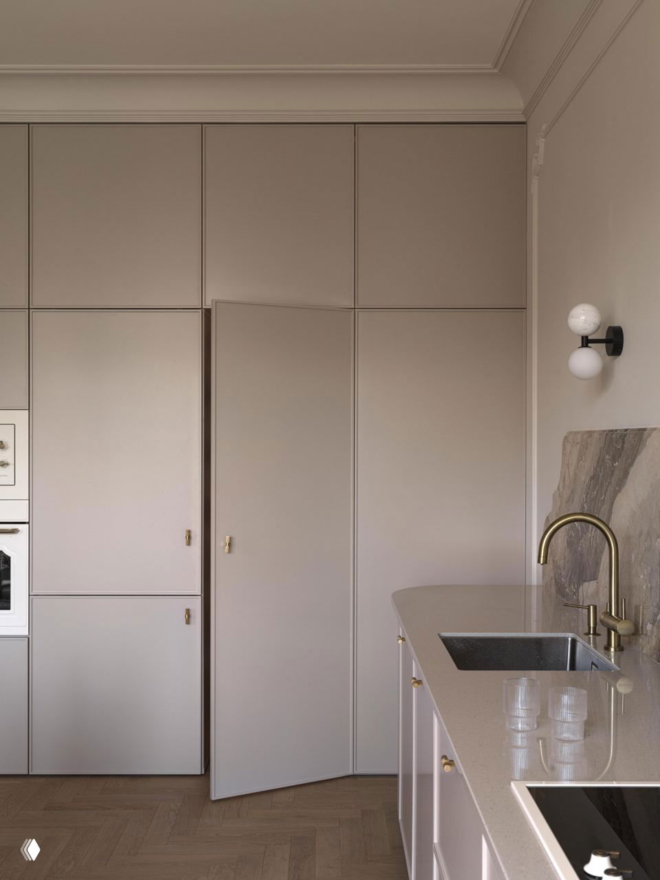 Высокие встроенные шкафы в тон стен и проходная дверца, компактная рабочая зона с выдвижной мойкой и бронзовым смесителем на фоне бежевого оформления.