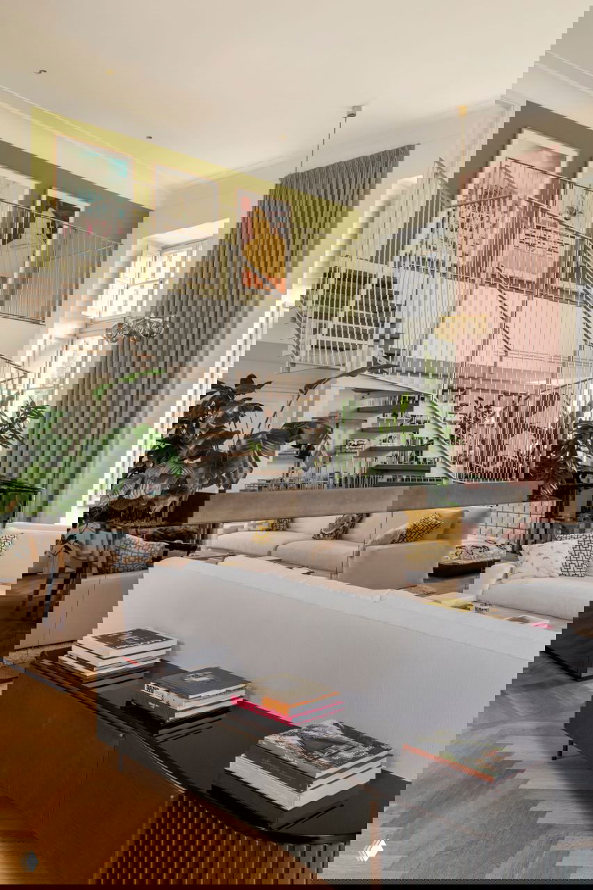 Гостиная с двухъярусной лестницей, зелёной стеной, роялем и светлыми диванами — сочетание современных и винтажных элементов в интерьере.