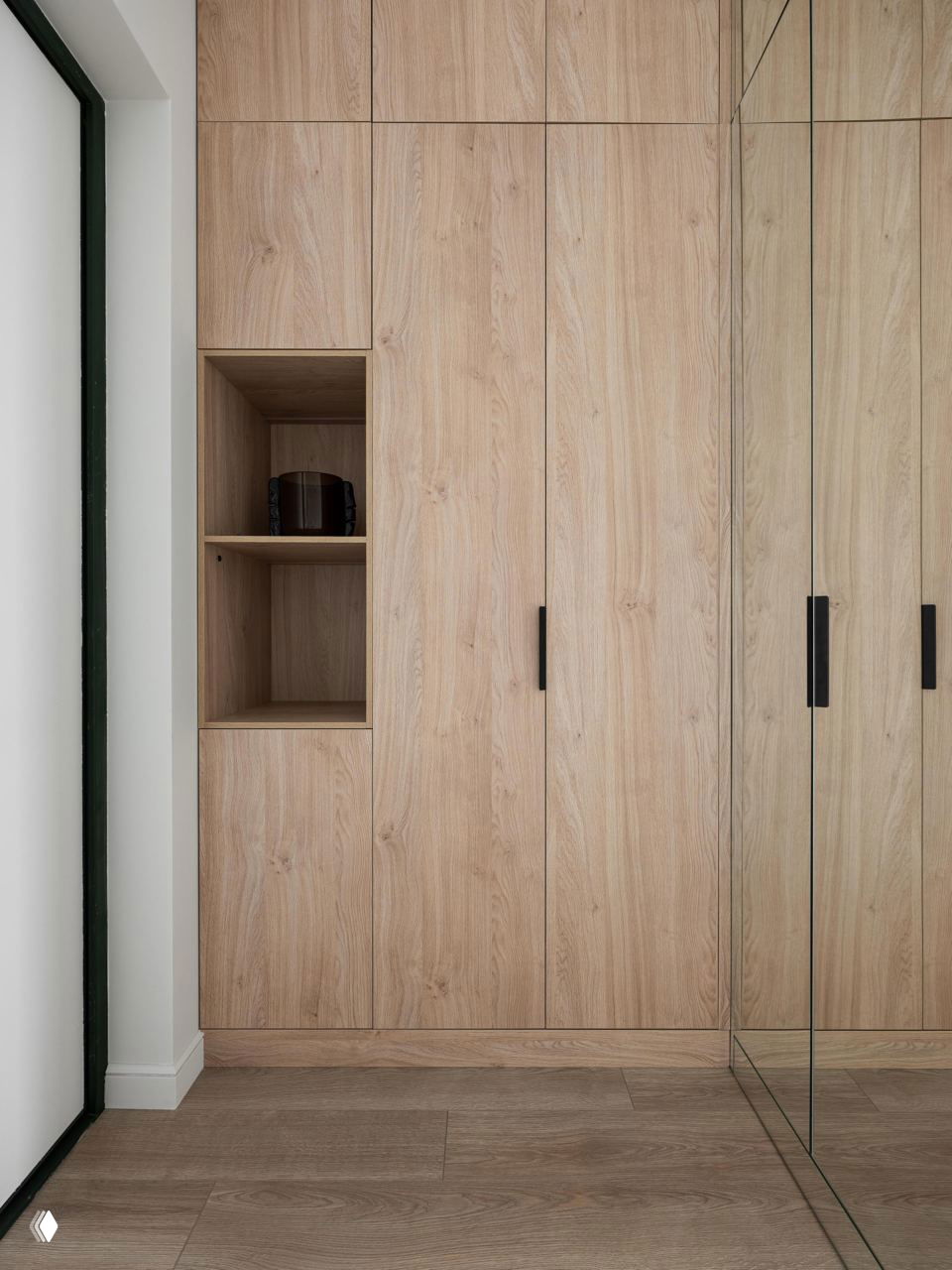 Встроенный шкаф под натуральное дерево и зеркало: лаконичная прихожая с зеркальной панелью и деревянной фактурой фасадов, полы в светлом тоне.