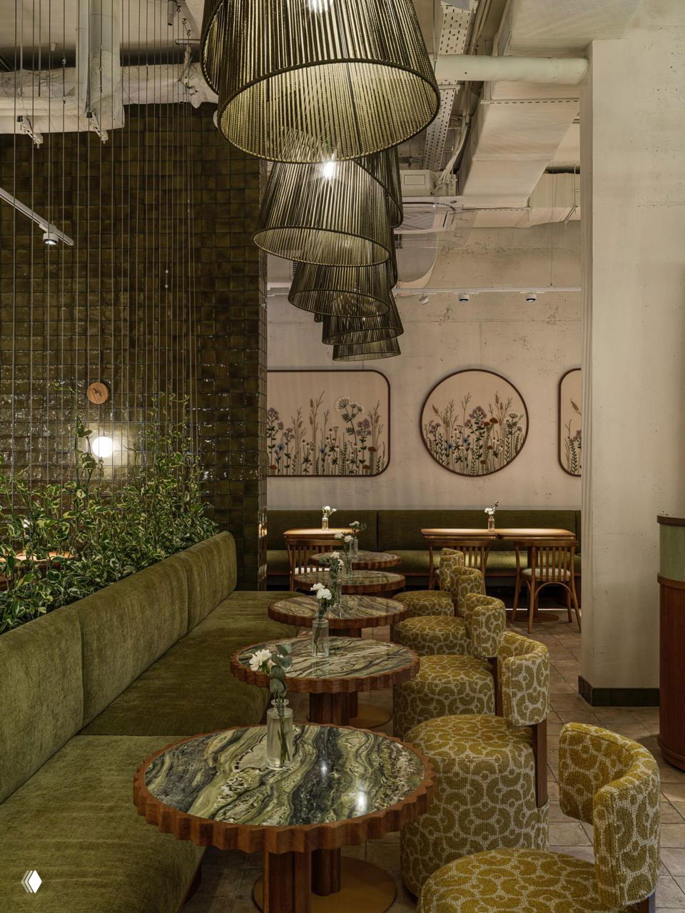 Скамья у стены с вышитыми панно: округлые и прямоугольные рамки с растительными мотивами, зелёный текстиль и простая деревянная мебель в пастельных тонах.