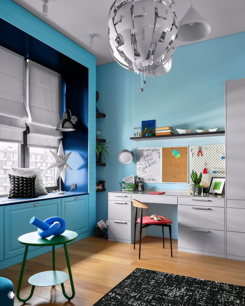Рабочая зона в голубых тонах: встроенные полки, доска для заметок и стол у окна, обеспечивающие организованное пространство для учебы и творчества.
