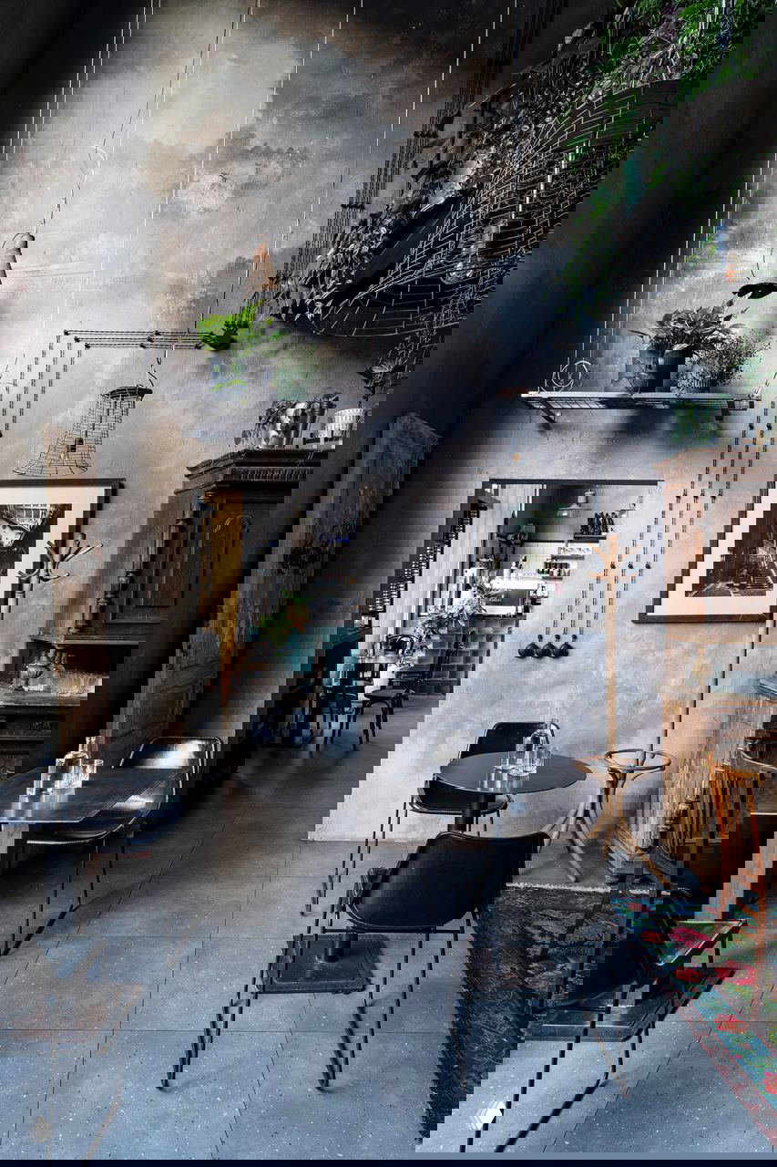 Столы и стулья на плиточном полу, подвесные растения и чёрная металлическая галерея на фоне шестиметровых стен — сочетание ретро и индустриального стиля в кафе «Ровесники», фото Кирилла Овчинникова.