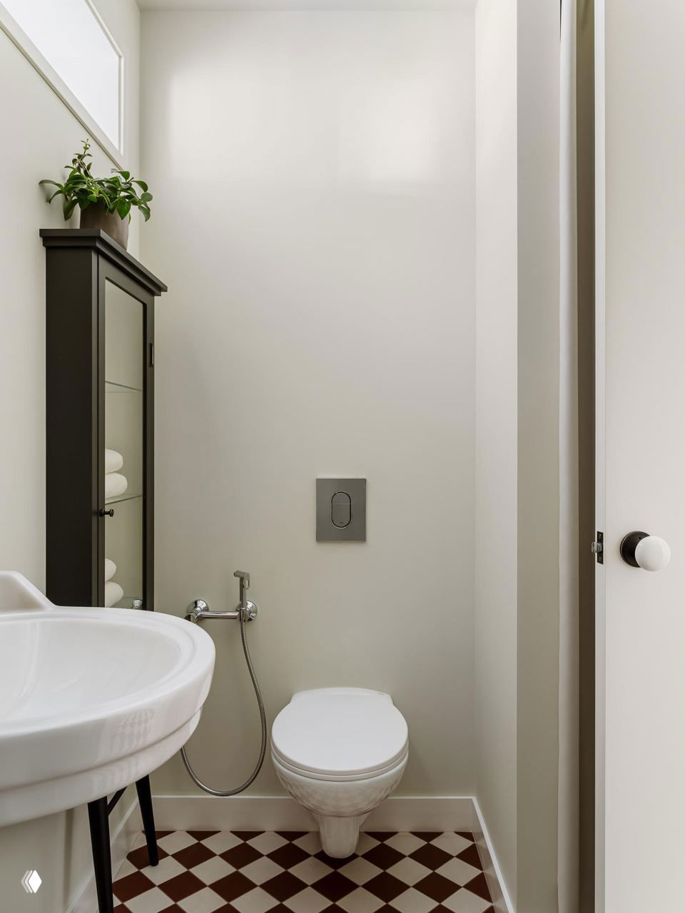 Минималистичный санузел с подвесным унитазом, круглой раковиной и узким шкафчиком для полотенец — светлый компактный туалет в хрущёвке.