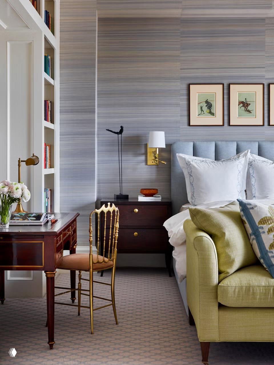 Элегантная спальня-кабинет с голубовато-серыми обоями, изящным письменным столом, мягким изголовьем и встроенными стеллажами для книг и декора — сочетание работы и отдыха.