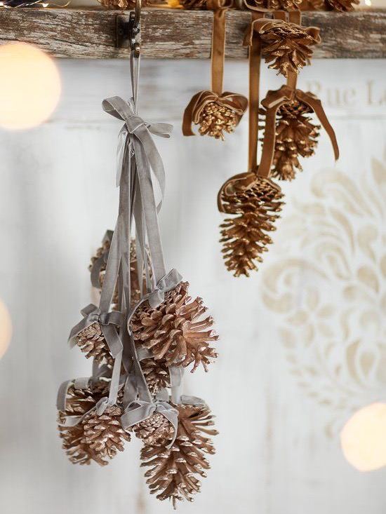 Подвесная гирлянда из нескольких окрашенных и натуральных шишек, перевязанных лентой — идея для простых самодельных подвесок и украшений интерьера.