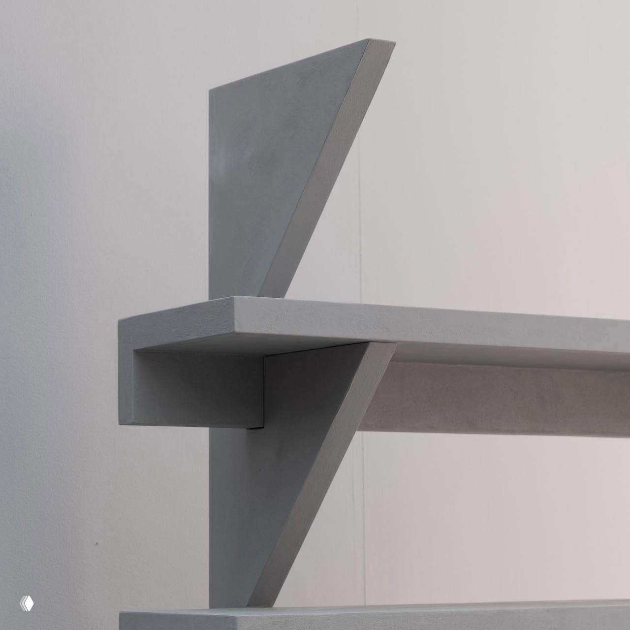 Деталь стеллажа из коллекции «Уют» Le Atelier: угловые опоры и полки с фактурой, имитирующей бетон, в минималистичной композиции