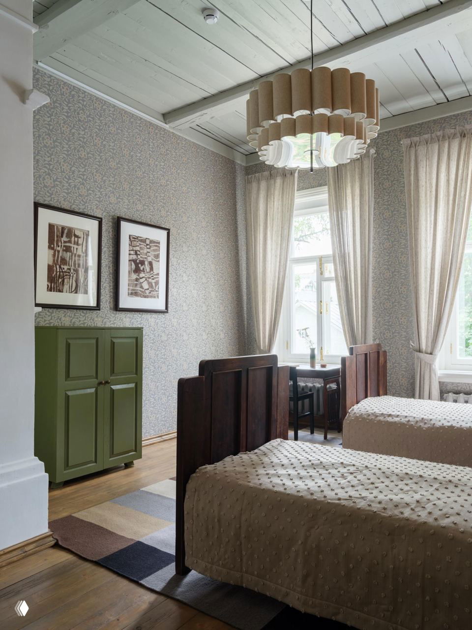 Спальня с двумя кроватями, высокими потолками и светлыми шторами; элементы старинной мебели и аксессуары в интерьере отеля в Вологде.