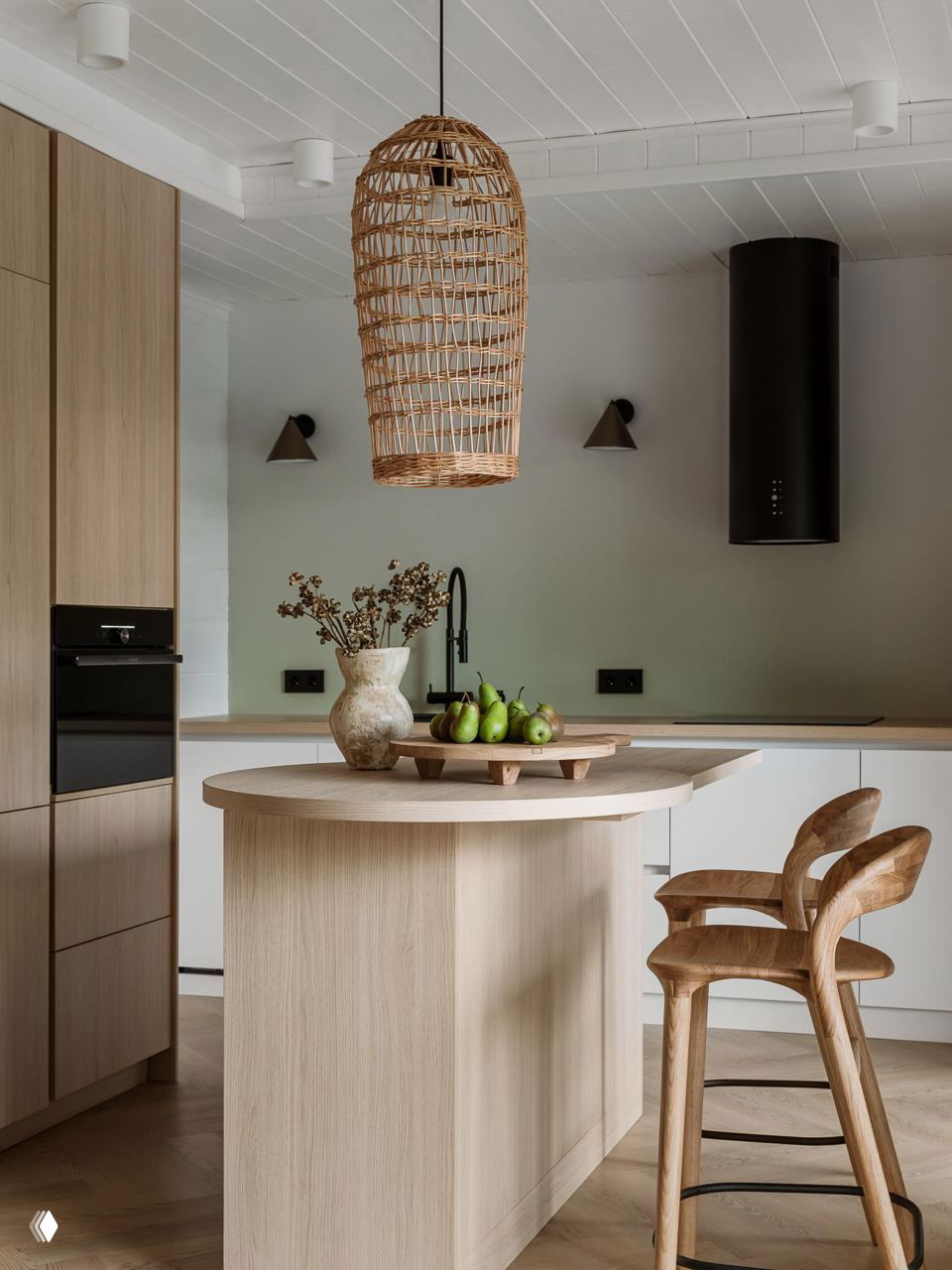 Кухня с островом из светлого дерева, стульями из массива и плетеной подвесной лампой — лаконичный натуральный интерьер и пастельные оттенки.