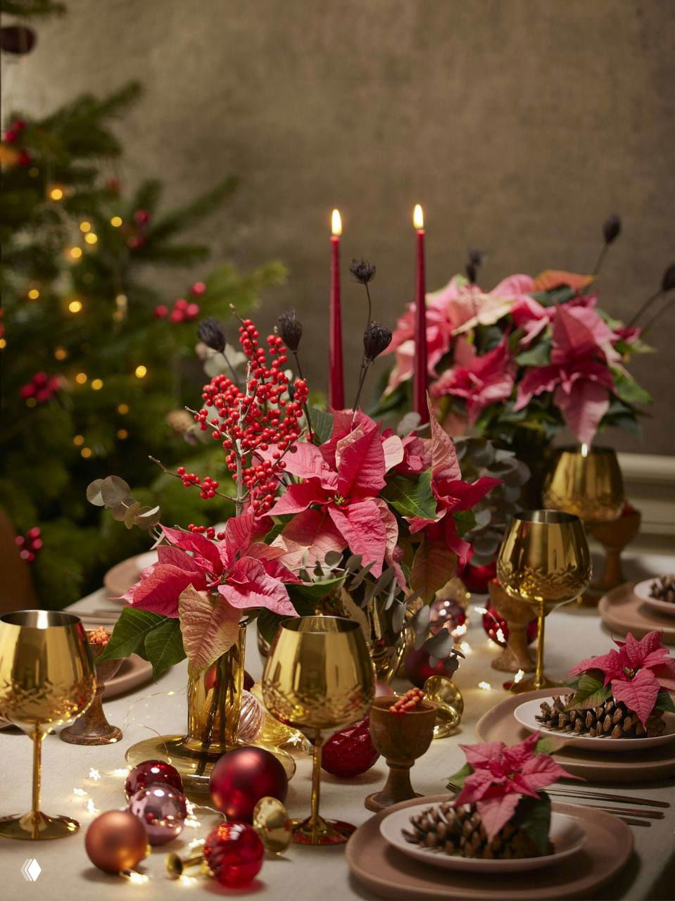Роскошная сервировка с золотыми бокалами и пуансеттией: тёплые металлические акценты и красочные цветочные элементы создают праздничный шик.