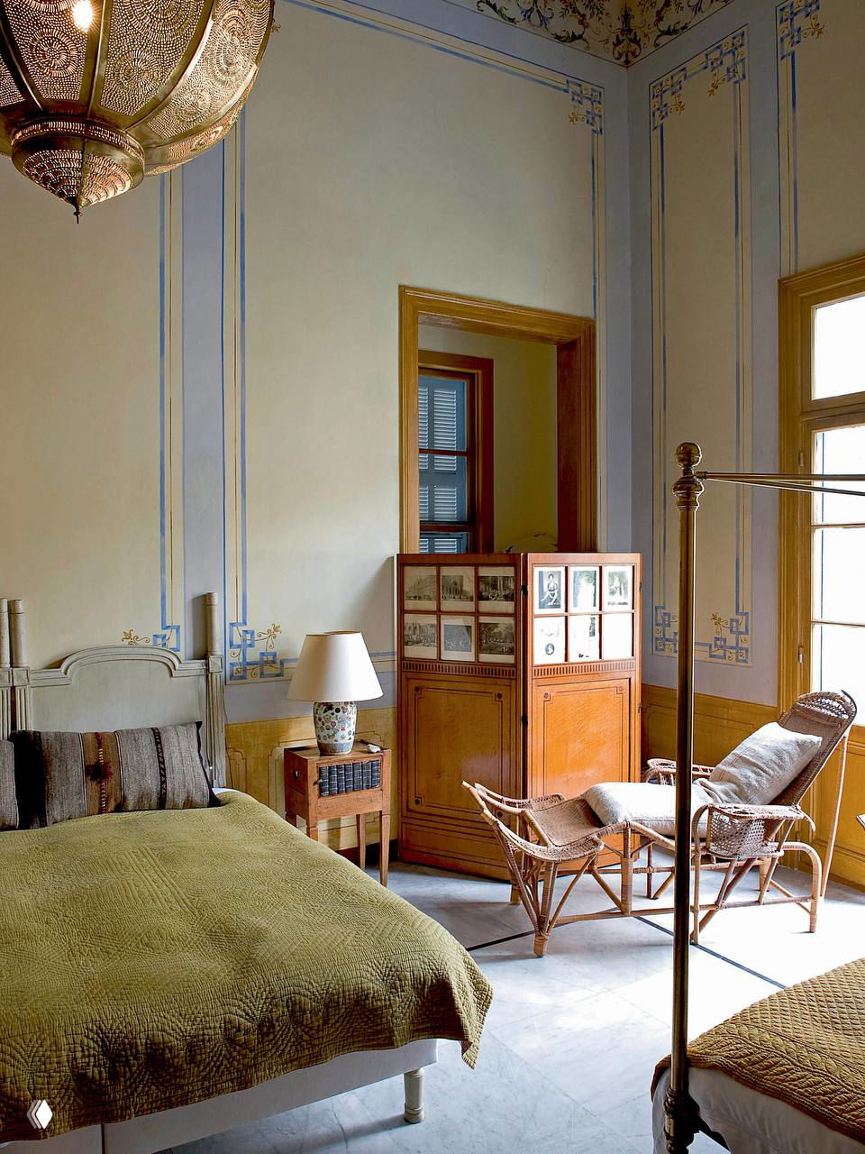 Спальня с высокими потолками и оливковыми стенами; винтажная мебель, текстиль оливкового тона и нежные классические орнаменты на стенах.