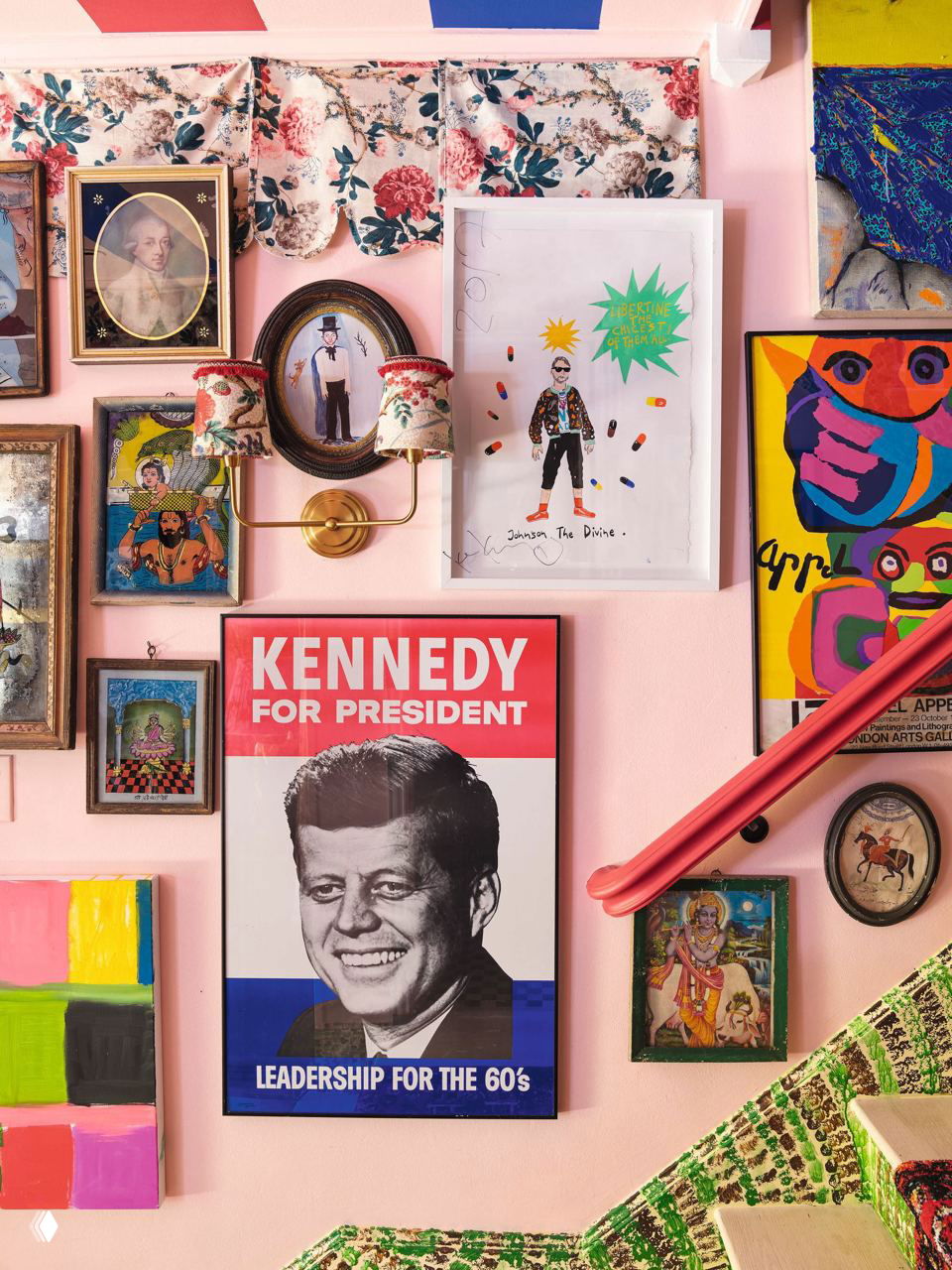 Коллаж на стене с плакатом «Kennedy for President», портретами и современными принтами на розовом фоне — пример смешения поп‑арт и винтажа в доме.