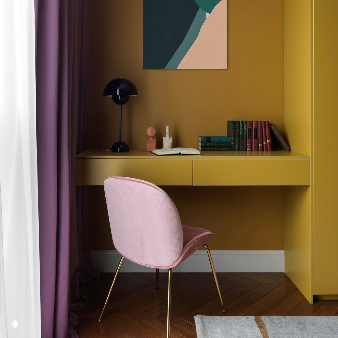 Рабочая зона с встроенным столом и шкафом горчичного цвета, розовое бархатное кресло и тяжёлые шторы у окна для контраста.