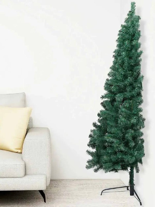 Узкая зелёная ёлка в углу у светлого дивана на нейтральном фоне — компактное решение для маленькой гостиной или студии.