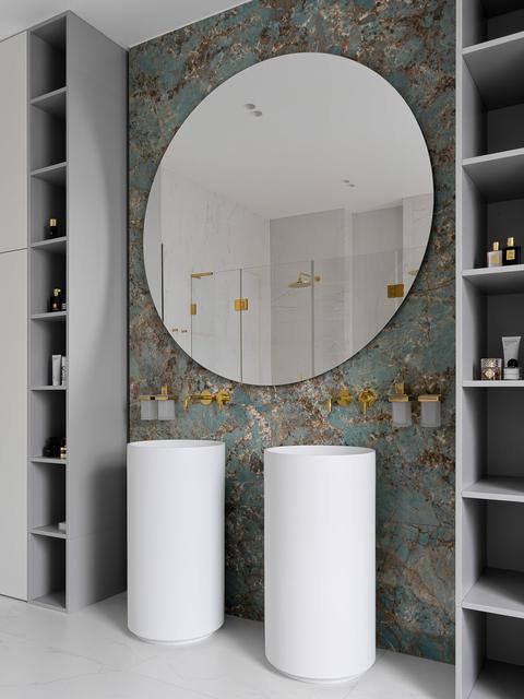 Санузел с двумя цилиндрическими раковинами, большим круглым зеркалом и декоративной стеной с бирюзово-золотой текстурой в доме Чекалиных.
