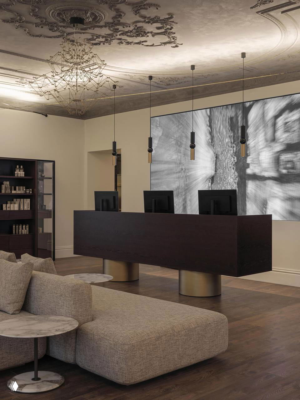 Ресепшн клиники с лепным потолком, низкой модульной софой и крупным чёрно‑белым панно, визуально напоминающим рентгеновский снимок в интерьере.