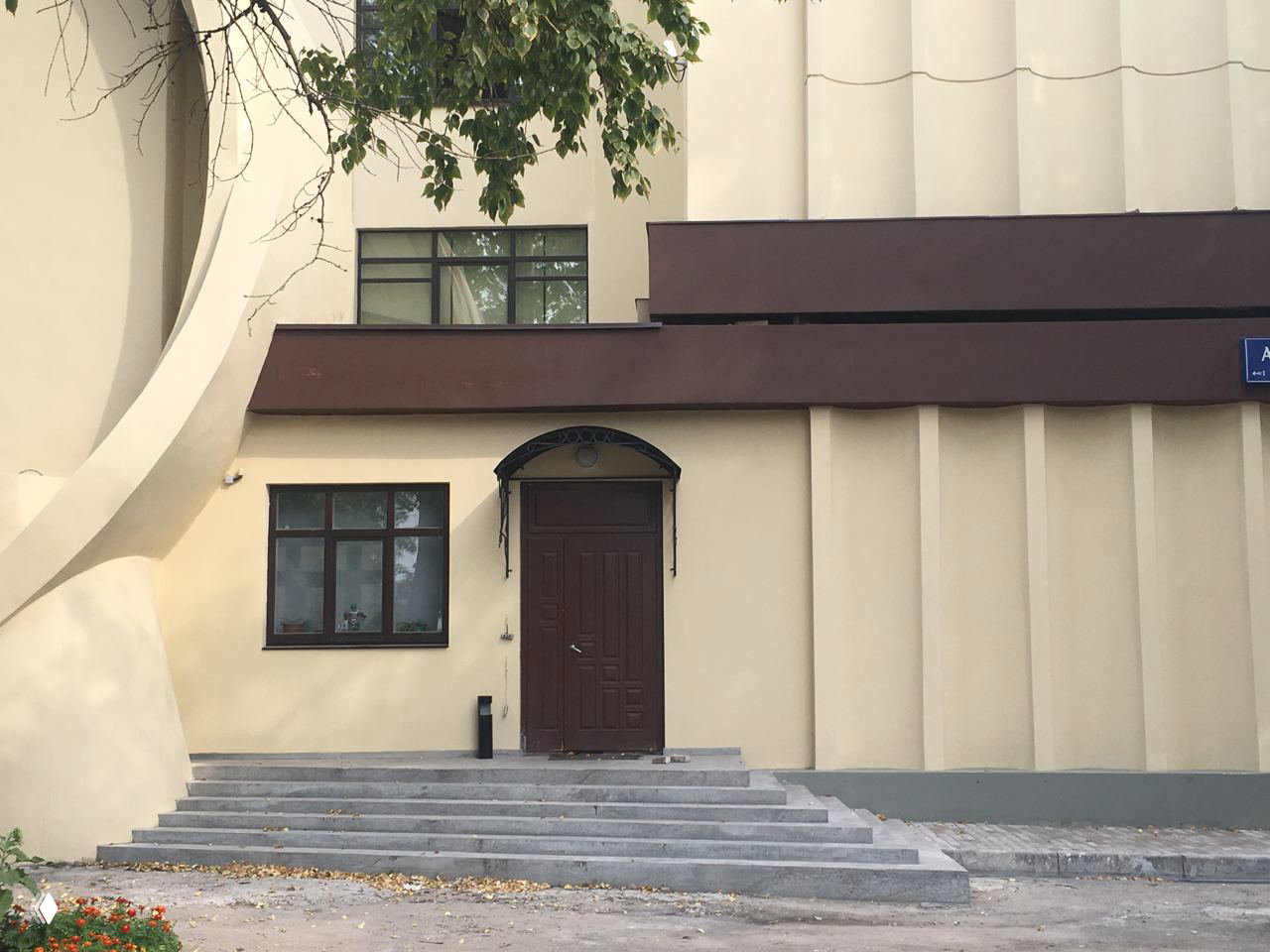 Деталь входной части и лестницы Гараж Госплана: бетонные формы, консоли и вертикальные рёбра административного блока рядом с дверью.