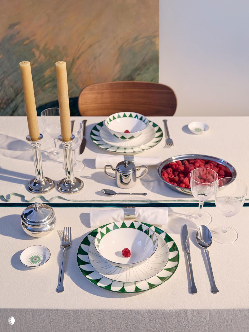 Столовая сервировка с тарелками из коллекции «Калейдоскоп»: зеркальная геометрия, зелёно-белые узоры, серебряная посуда и свежие ягоды на фоне светлой ткани.