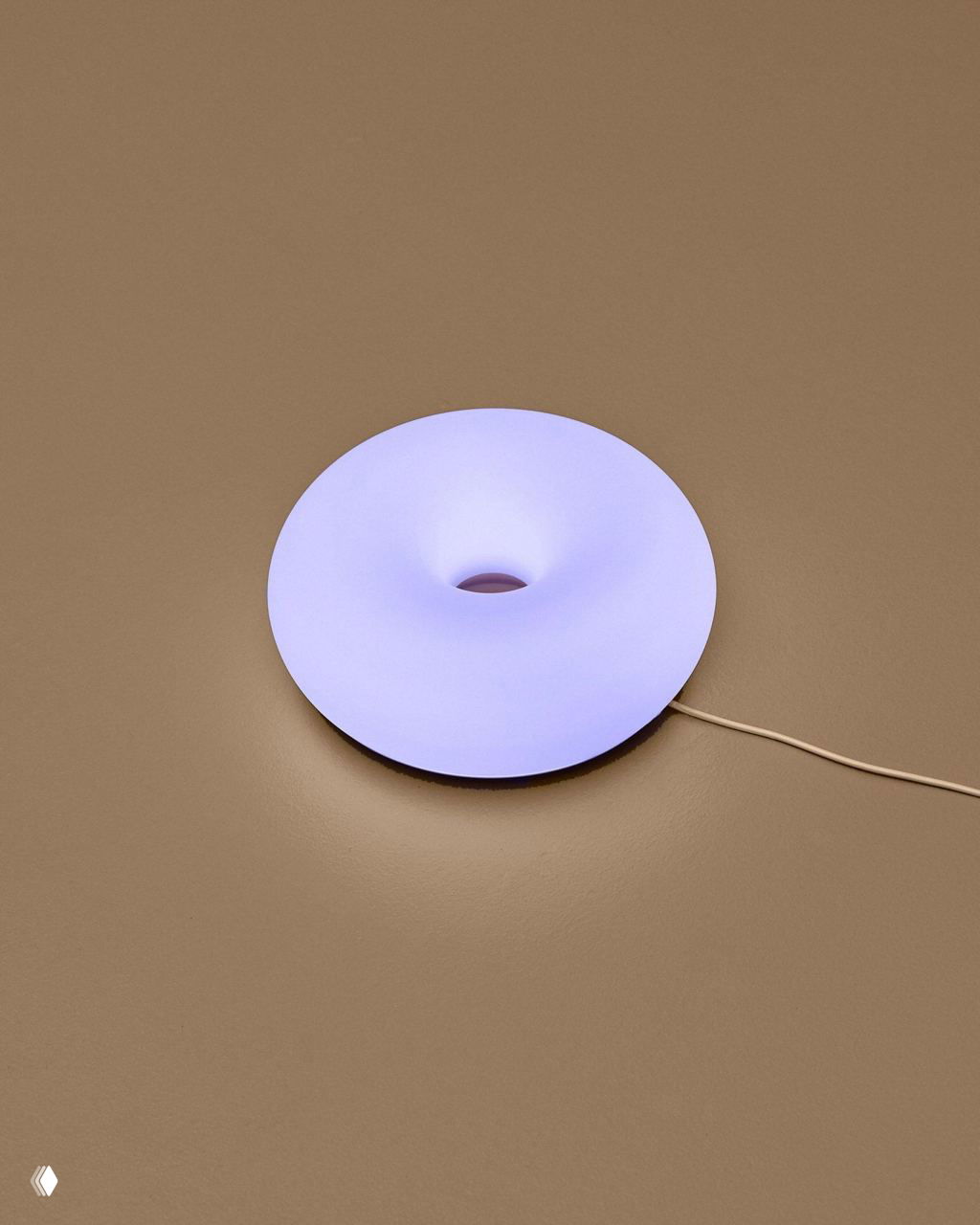 Фрагменты нескольких ламп‑пончиков под разными углами: матовая текстура корпуса и равномерное тёплое свечения в пастельной палитре, дизайнерская подача.