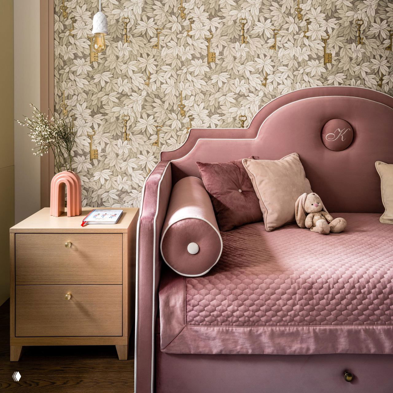 Ярко-розовый диван в нише белых шкафов и полок, рядом стеклянный столик и разноцветный ковёр — смелый цветовой акцент в городской квартире.