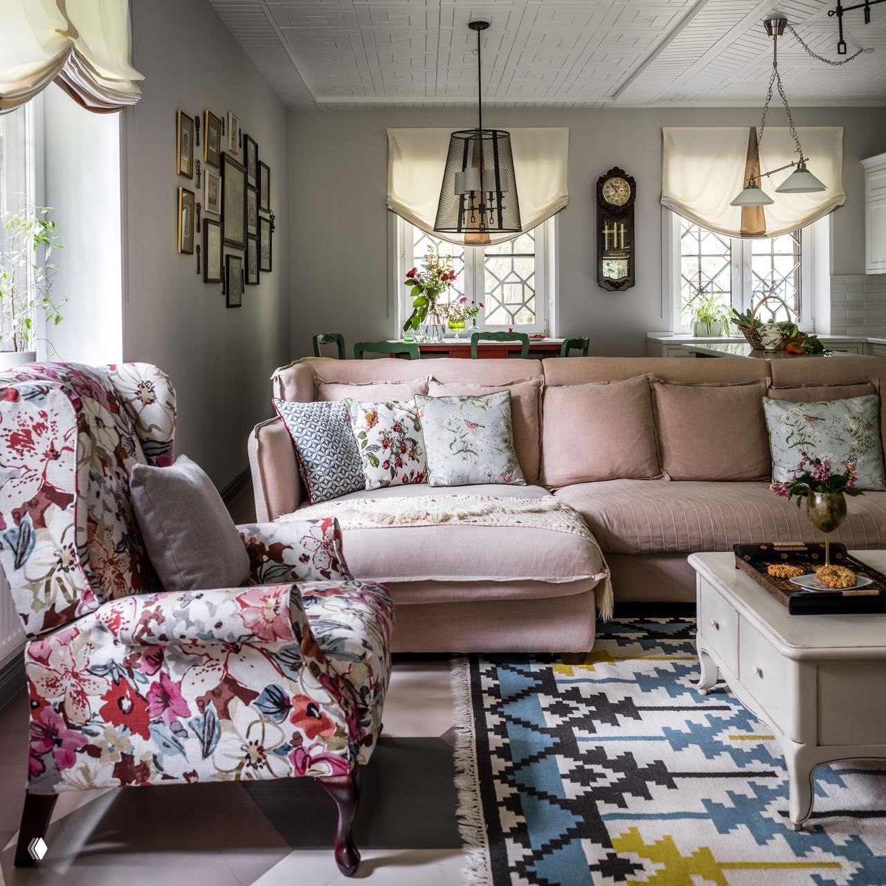 Розовый модульный диван рядом с открытой кухней и столовой зоной; длинные подушки и мягкий плед создают спокойный скандинавский образ гостиной.