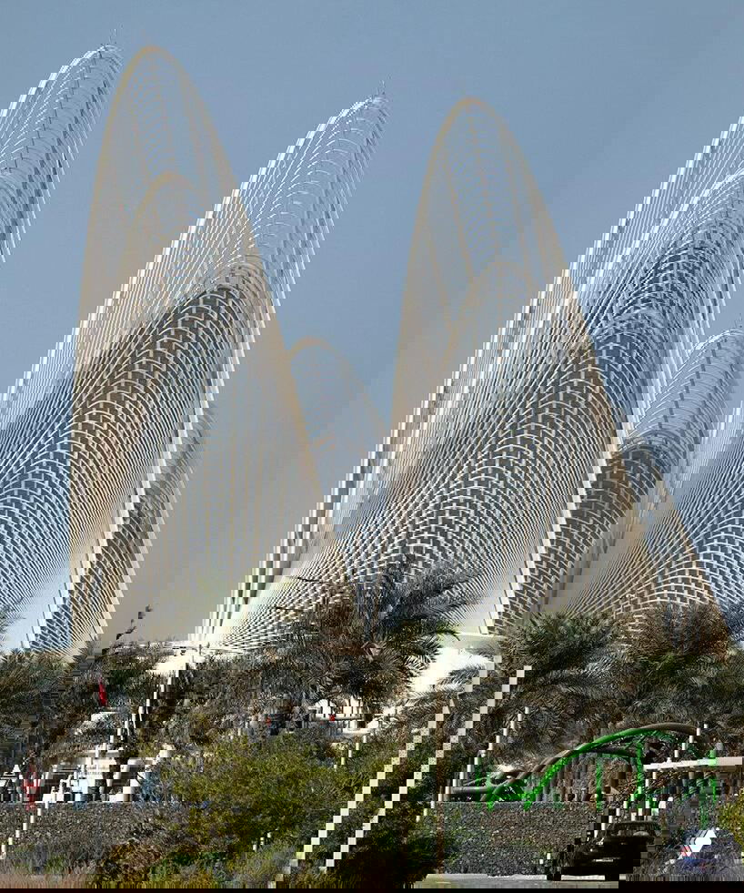 Перспективный вид на три высокие стальные «паруса» музея: сложная решётчатая структура, небо и пальмы внизу подчёркивают монументальность и контекст проекта.