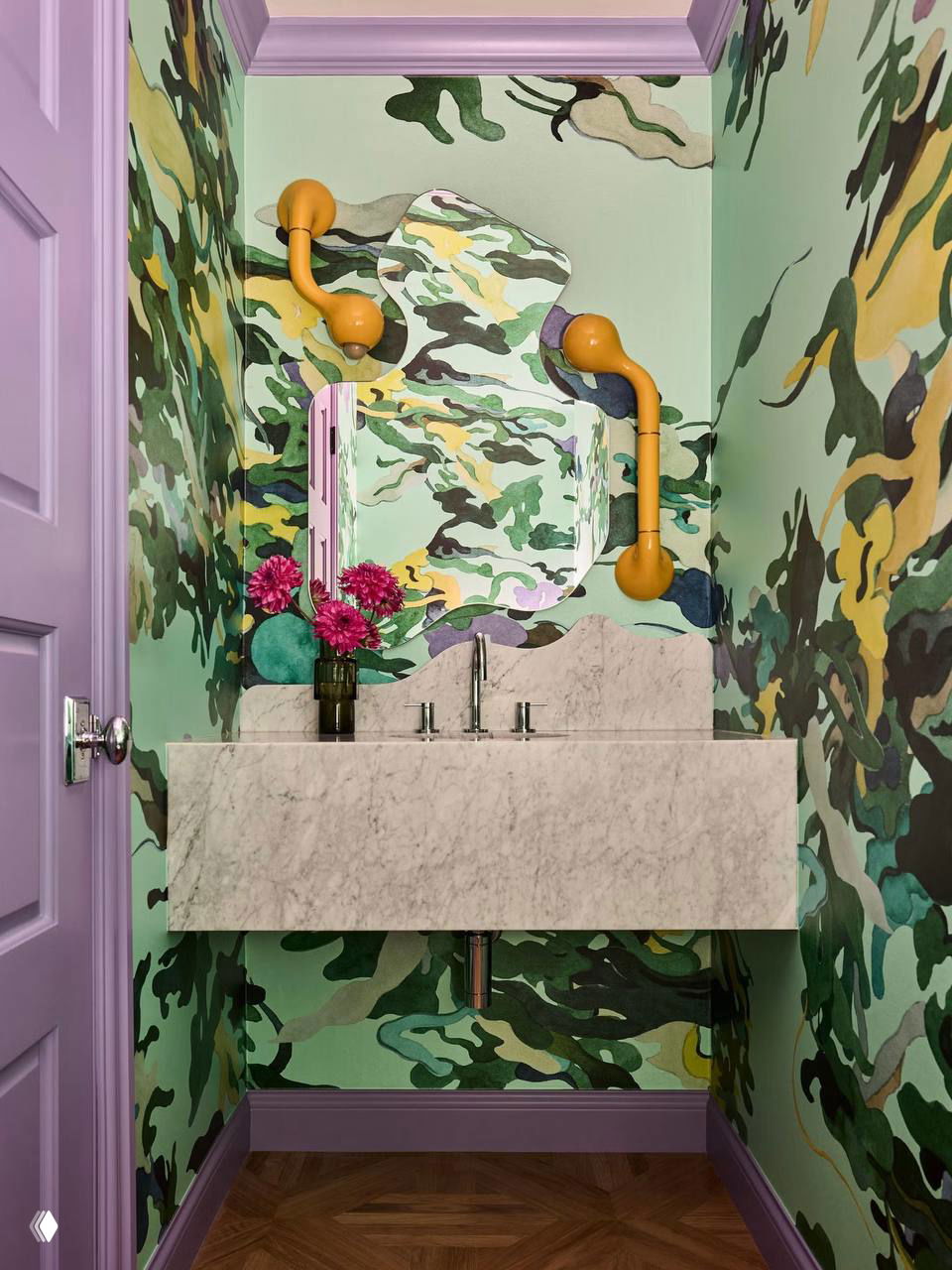 Необычные камуфляжные зелёные обои в маленьком санузле, фиолетовая отделка, современная мраморная столешница и встроенная раковина.