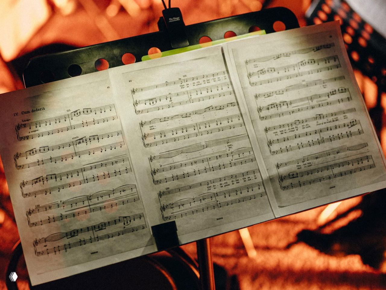 Партитура на пюпитре под тёплым светом — листы нотного текста как часть сценического антуража и музыкального исполнения Silent Opera.