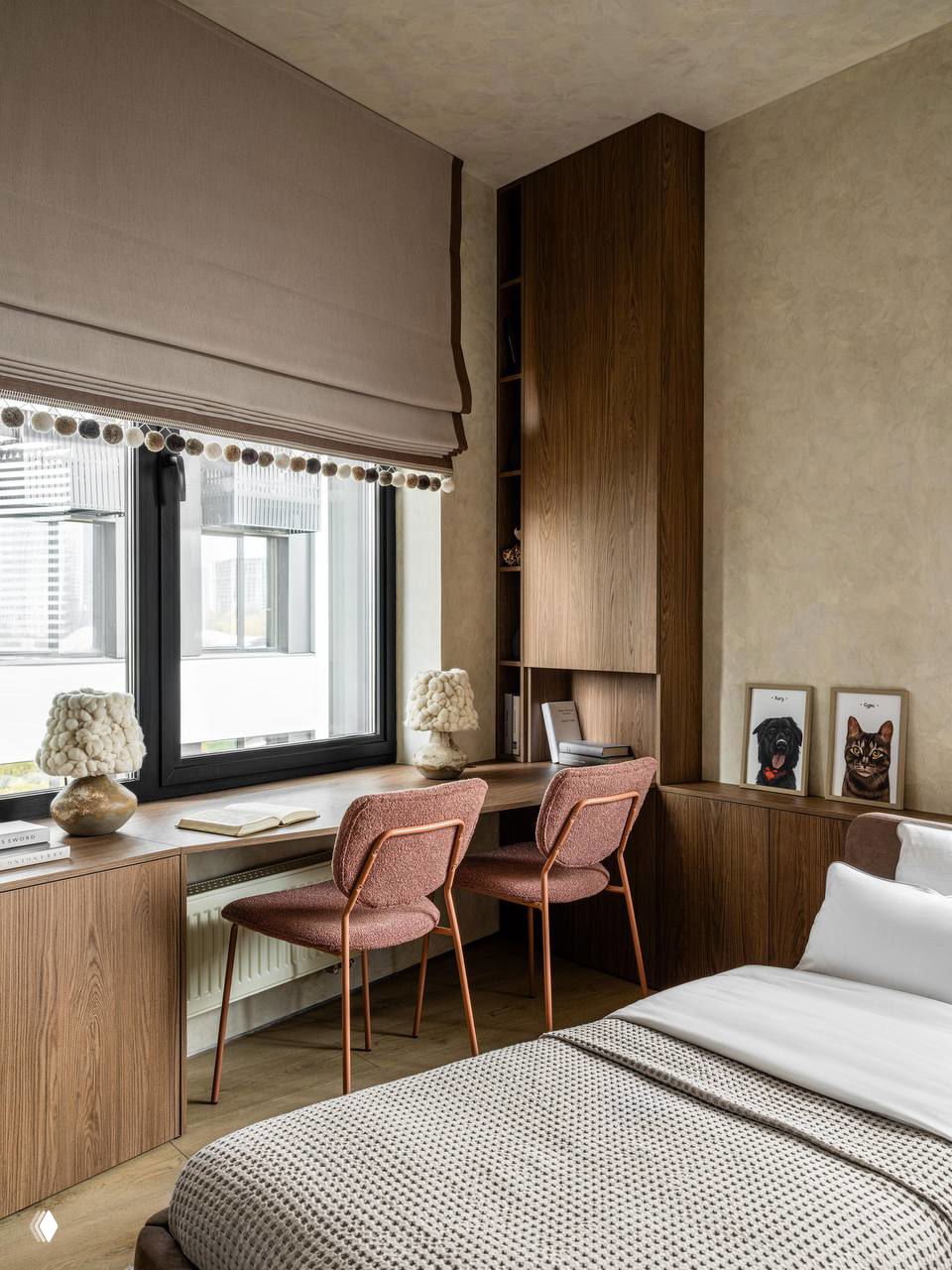 Рабочее место у окна и спальня: встроенные деревянные шкафы, стол-подоконник, две мягкие стулья терракотового оттенка и декоративные элементы на подоконнике.
