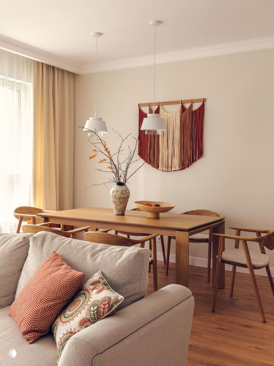 Обеденная зона с деревянным столом, макраме на стене и подвесными светильниками — спокойный натуральный интерьер с мягкими текстурами и растительными акцентами.