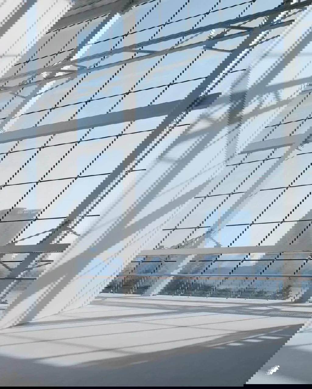 Панорамные стёкла и стальные конструкции музея с видом на городской пейзаж Шанхая, свет и тени подчеркивают пространственную структуру здания.