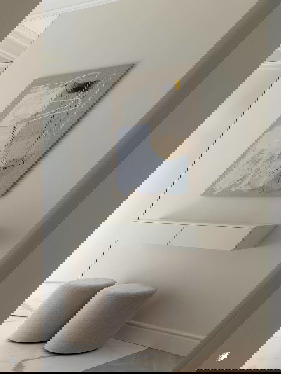 Прихожая и декоративная консоль на стене, два мягких пуфа и абстрактная картина — компактное и аккуратное пространство у входа.