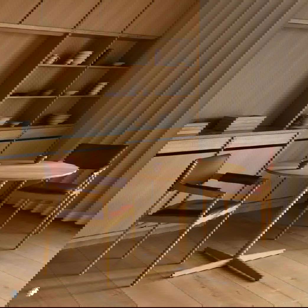 Минималистичный деревянный стол и два стула в спокойной натуральной гамме — пример лаконичной мебели шведского дизайна от классических производителей.