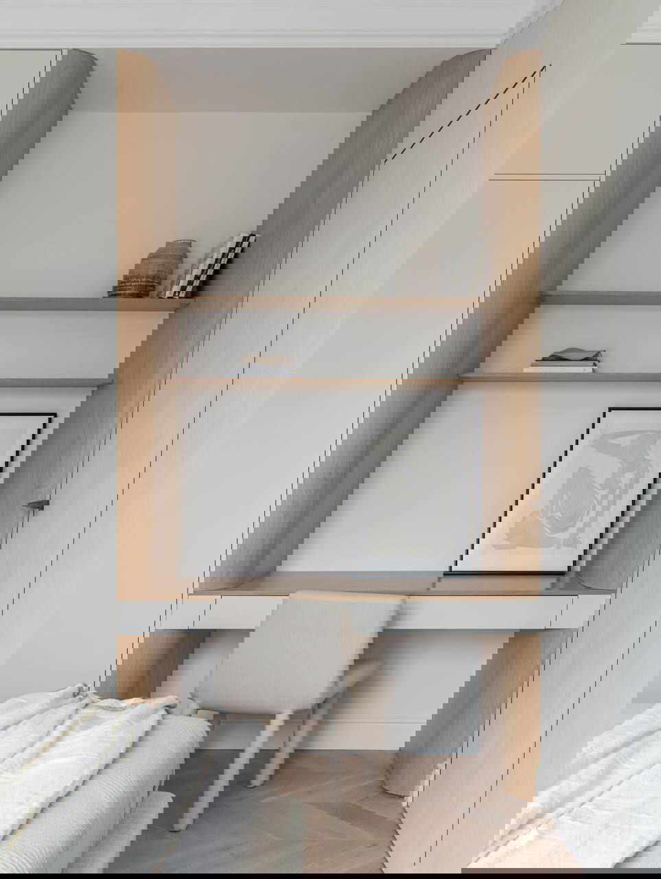 Рабочий стол у кровати: небольшой письменный стол со стулом, открытые полки и декор в спокойной палитре — уютный уголок для работы.