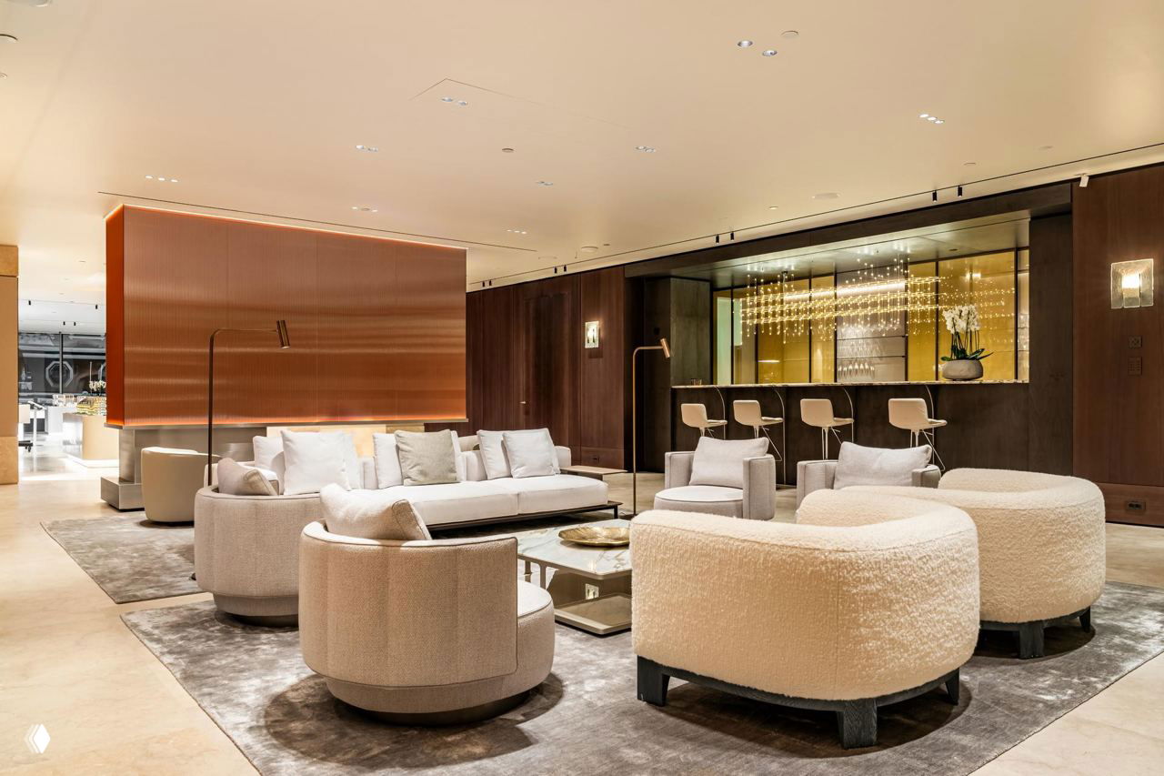 Мягкая гостиная с круглыми креслами и диваном в текстуре bouclé, в интерьере — большие ковры и минималистичные столики.