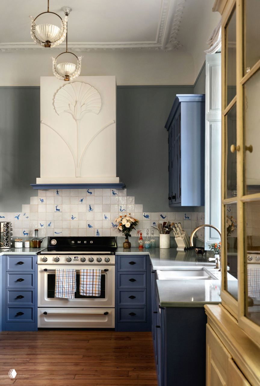 Кухня в пастельных синих тонах с плиткой над плитой, ретро-плитой SMEG и деревянным полом — сочетание классики и современного ретро.