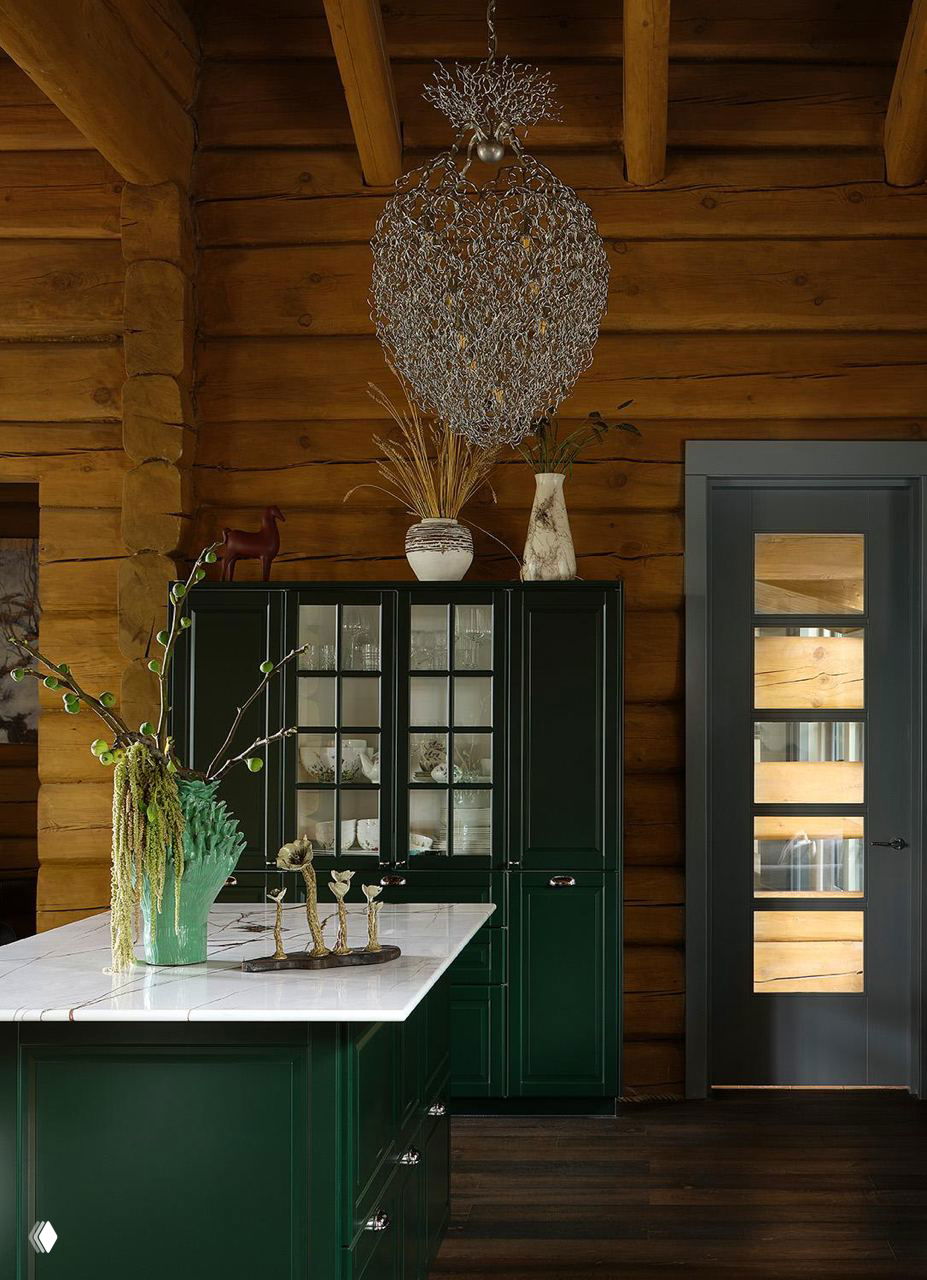 Кухня с тёмно-зелёным гарнитуром, мраморной столешницей и крупной подвесной лампой под деревянными балками; проект в Подмосковье.