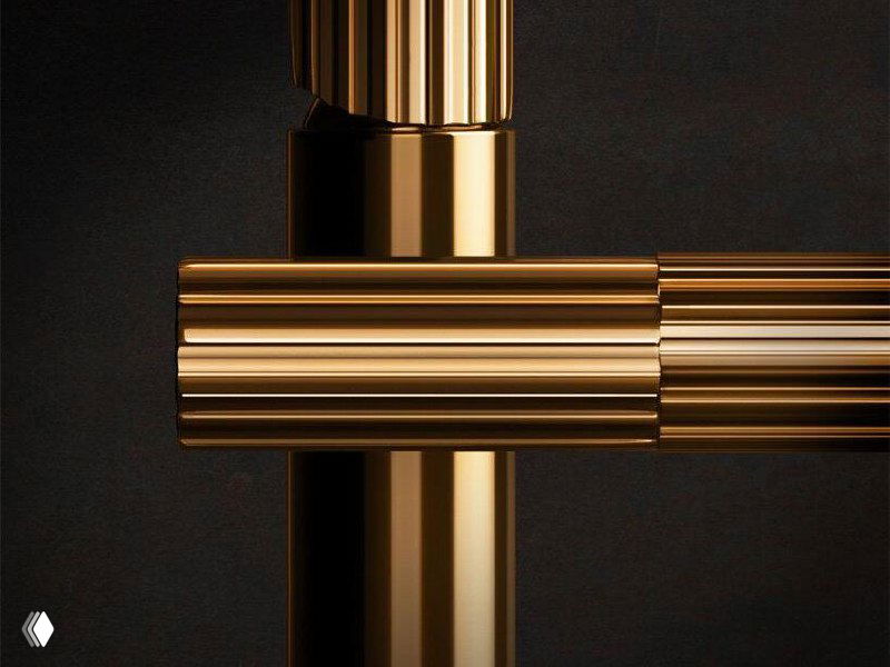 Макро-кадр смесителя: хромированные и тёплые металлические элементы на тёмном фоне, подчёркнуты линейной фактурой.