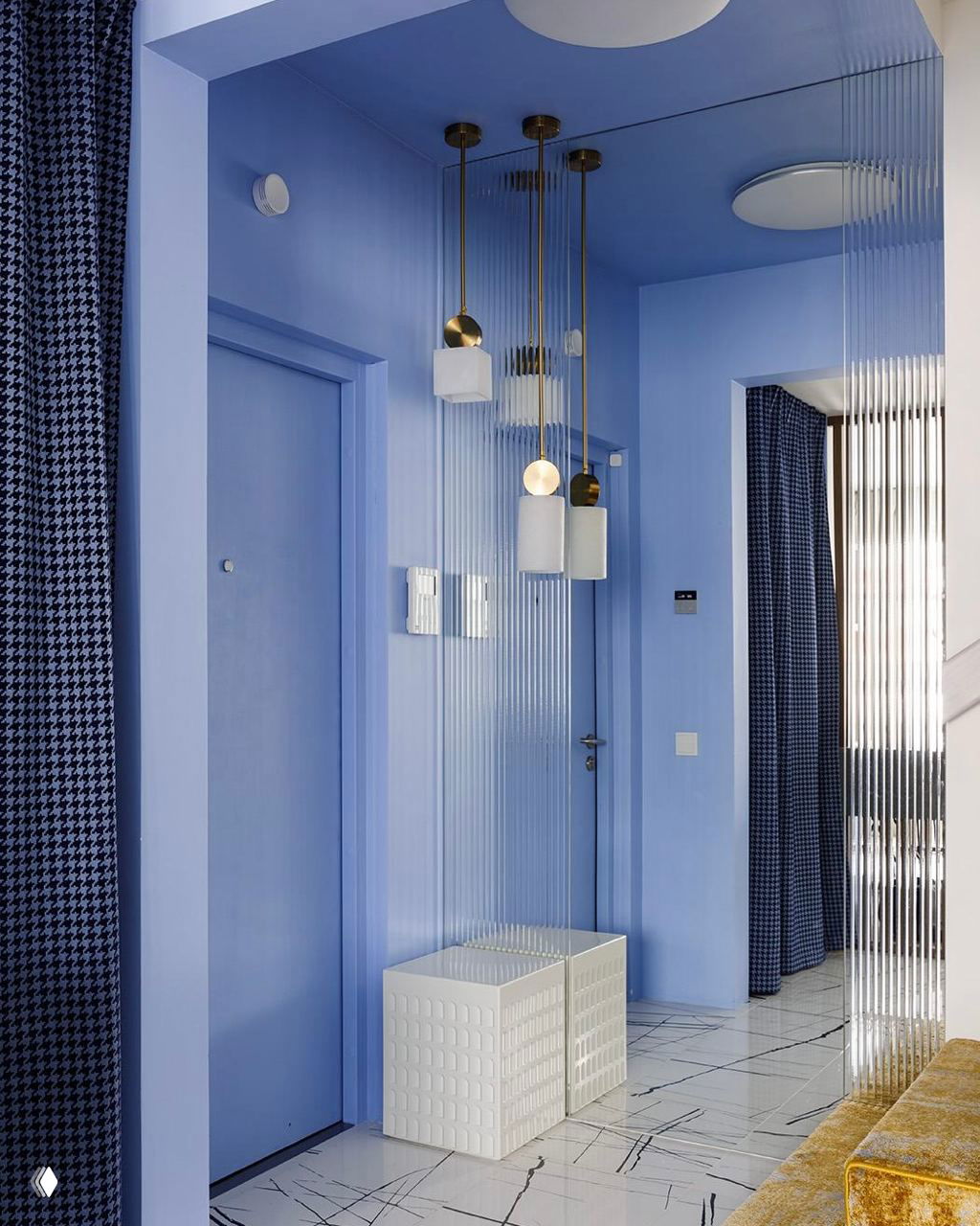 Современная узкая прихожая полностью в голубой палитре: стены и потолок окрашены в насыщенный голубой, подвесные лампы и прозрачная рифлёная перегородка усиливают объем пространства.