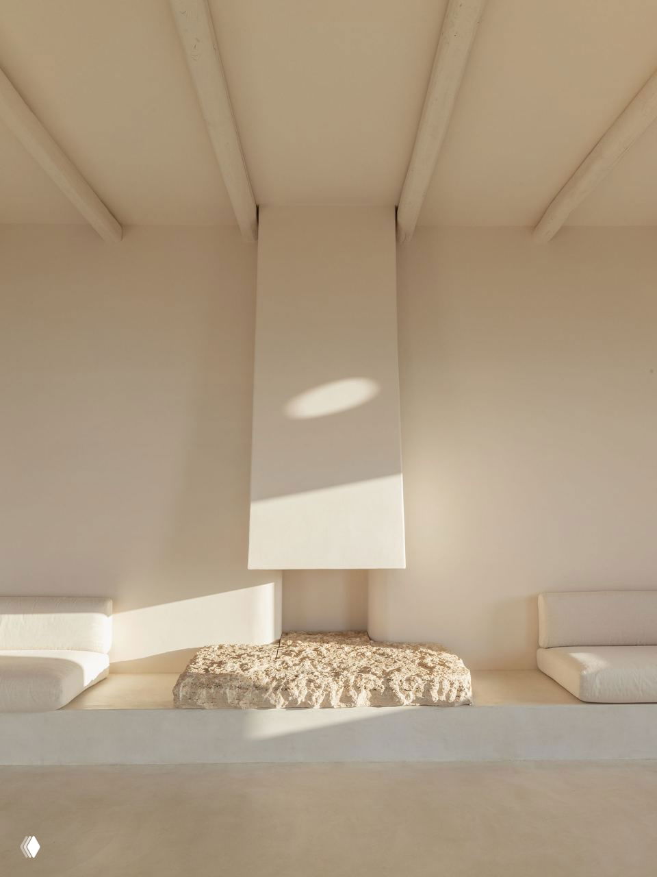 Каминный уголок с рельефным каменным элементом и белыми облицовками, минималистичная композиция для созерцания и релакса.