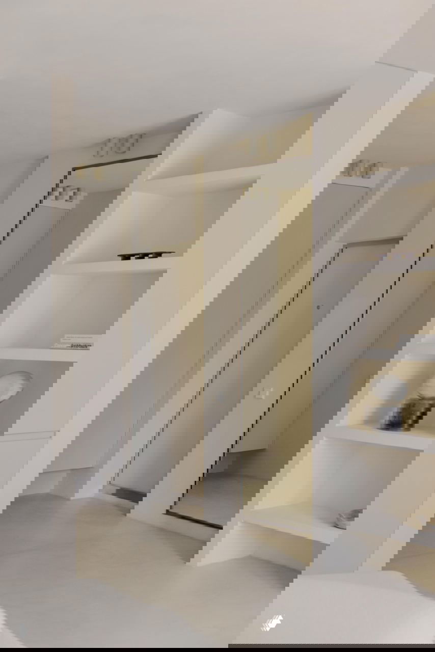 Прихожая и встроенные ниши: чистые линии, нейтральная отделка, большое зеркало и аккуратно организованные полки в минималистичном стиле.